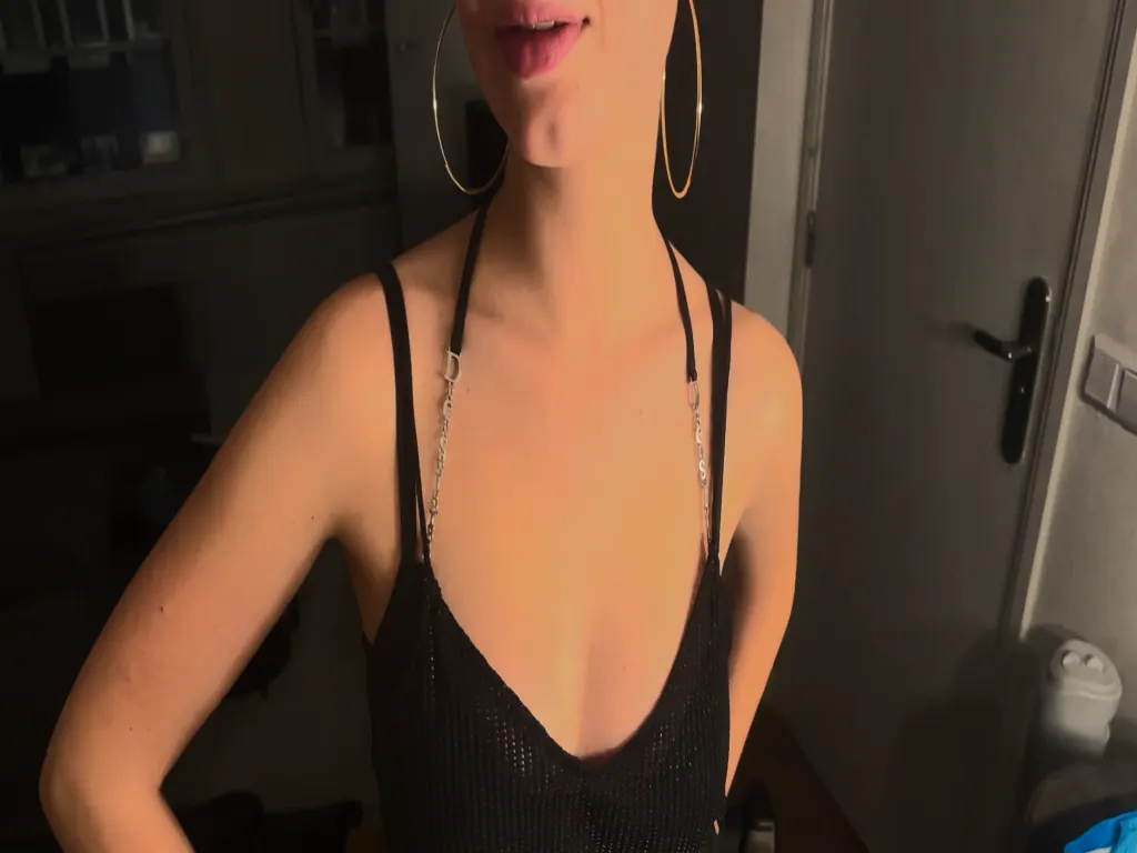 A black lace camisole and gold hoops in a dim hallway